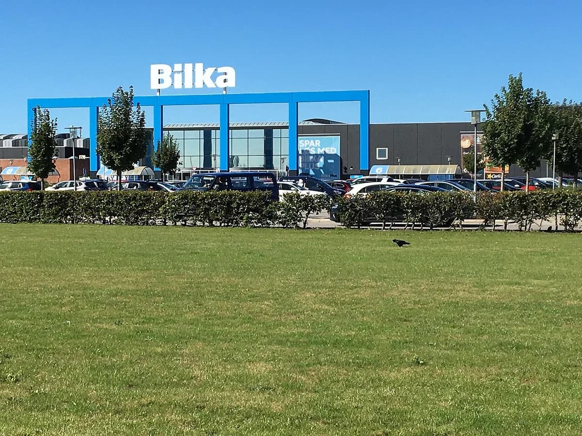 Bilka supermarket building with parking lot and grassy foreground.