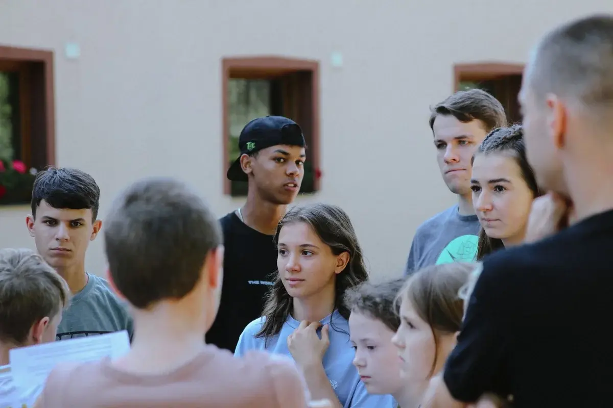 Teenagers gathered outdoors talking in a group.