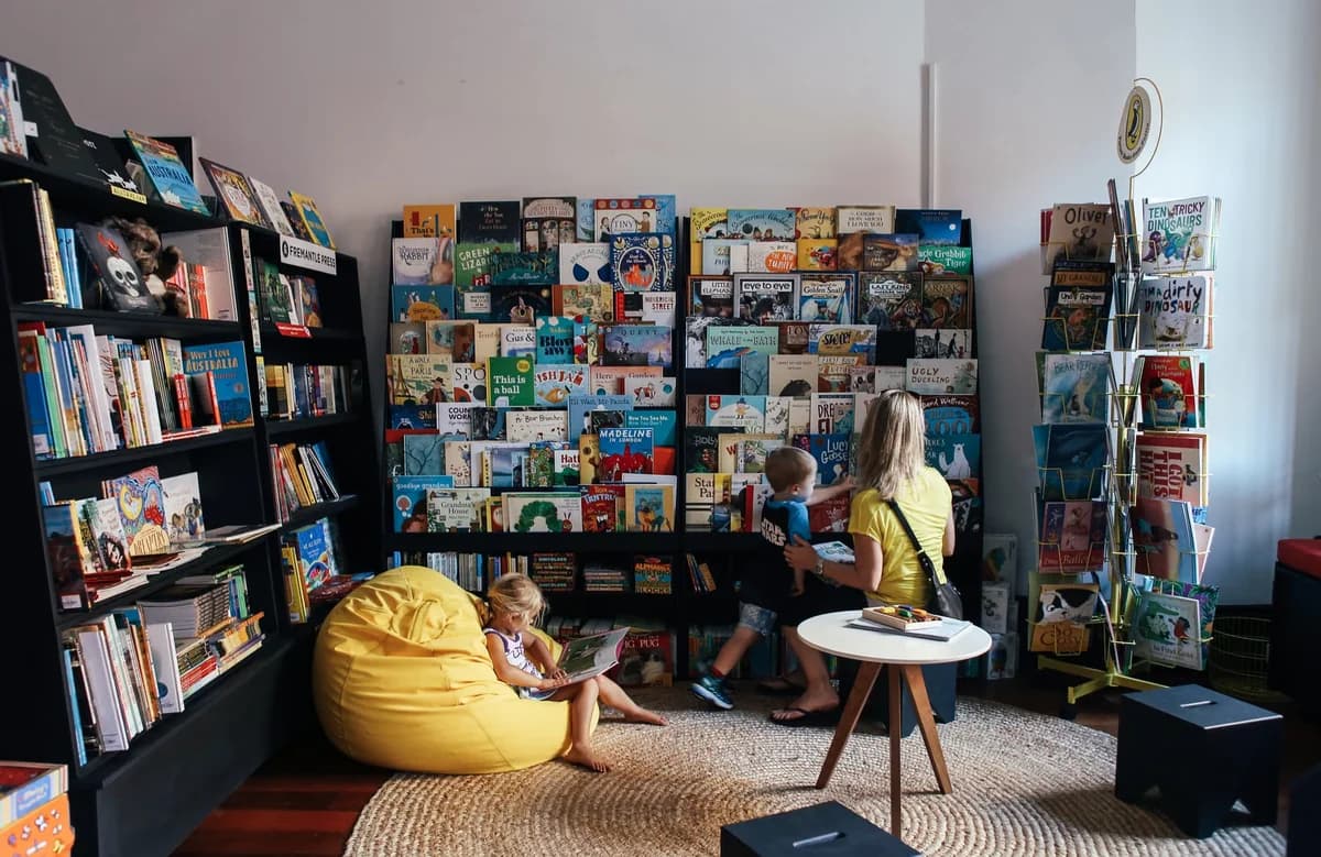 mother and children reading near colorful bookshelves