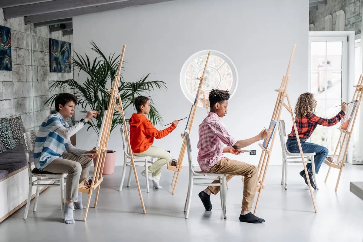 Children painting at easels in an indoor art class