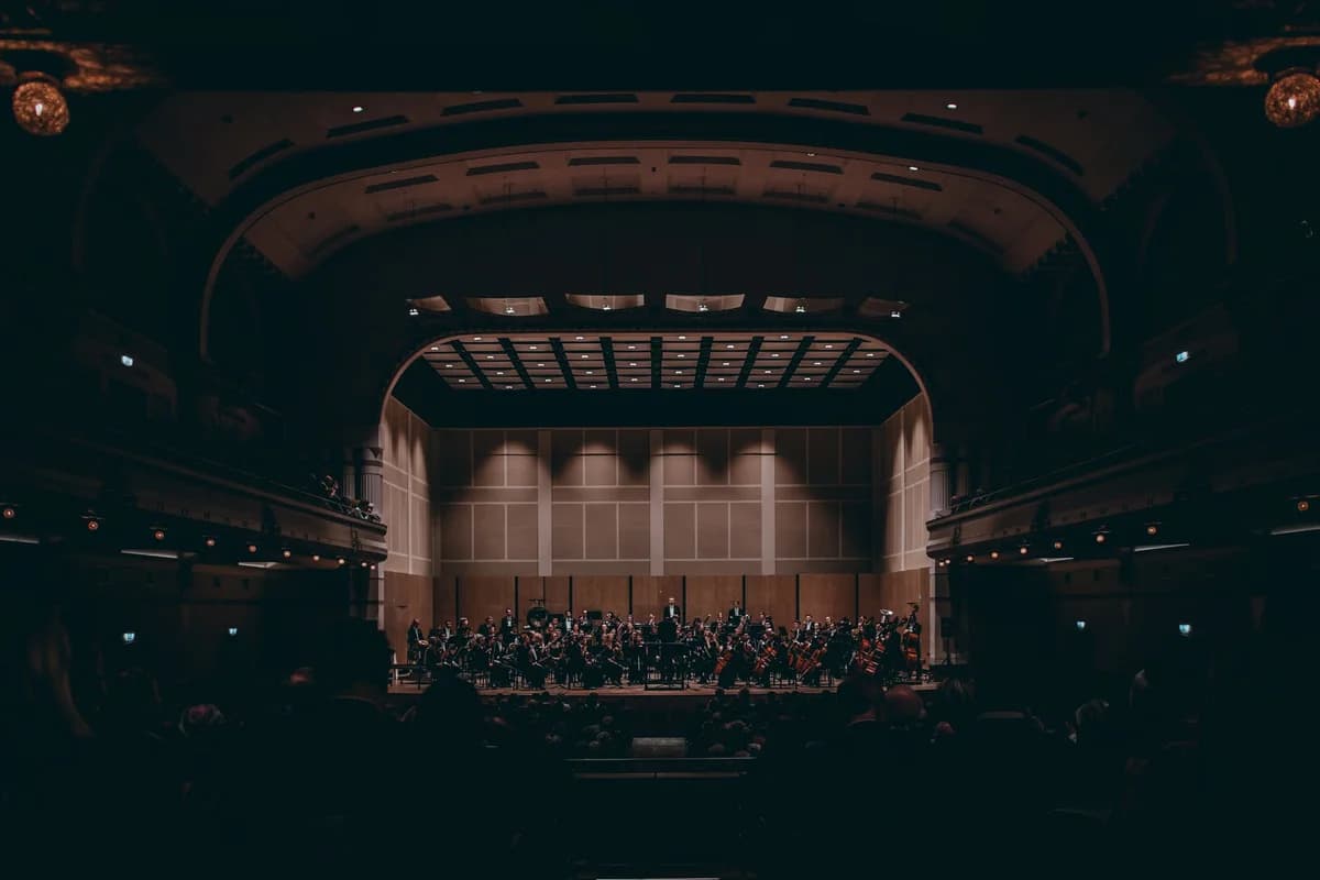 Symphony orchestra performing on stage in a large theater.