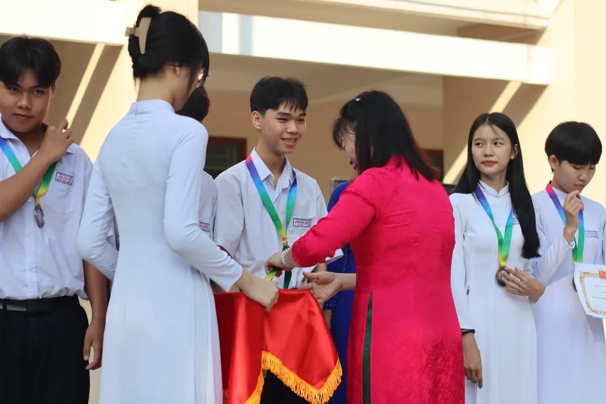 Students wearing medals and holding certificates at a school ceremony