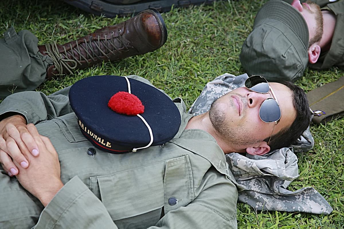 Men in military-style uniforms lying on grass