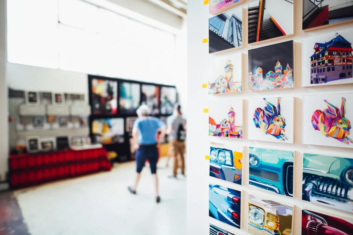 Colorful artworks displayed in a modern art gallery with visitors nearby