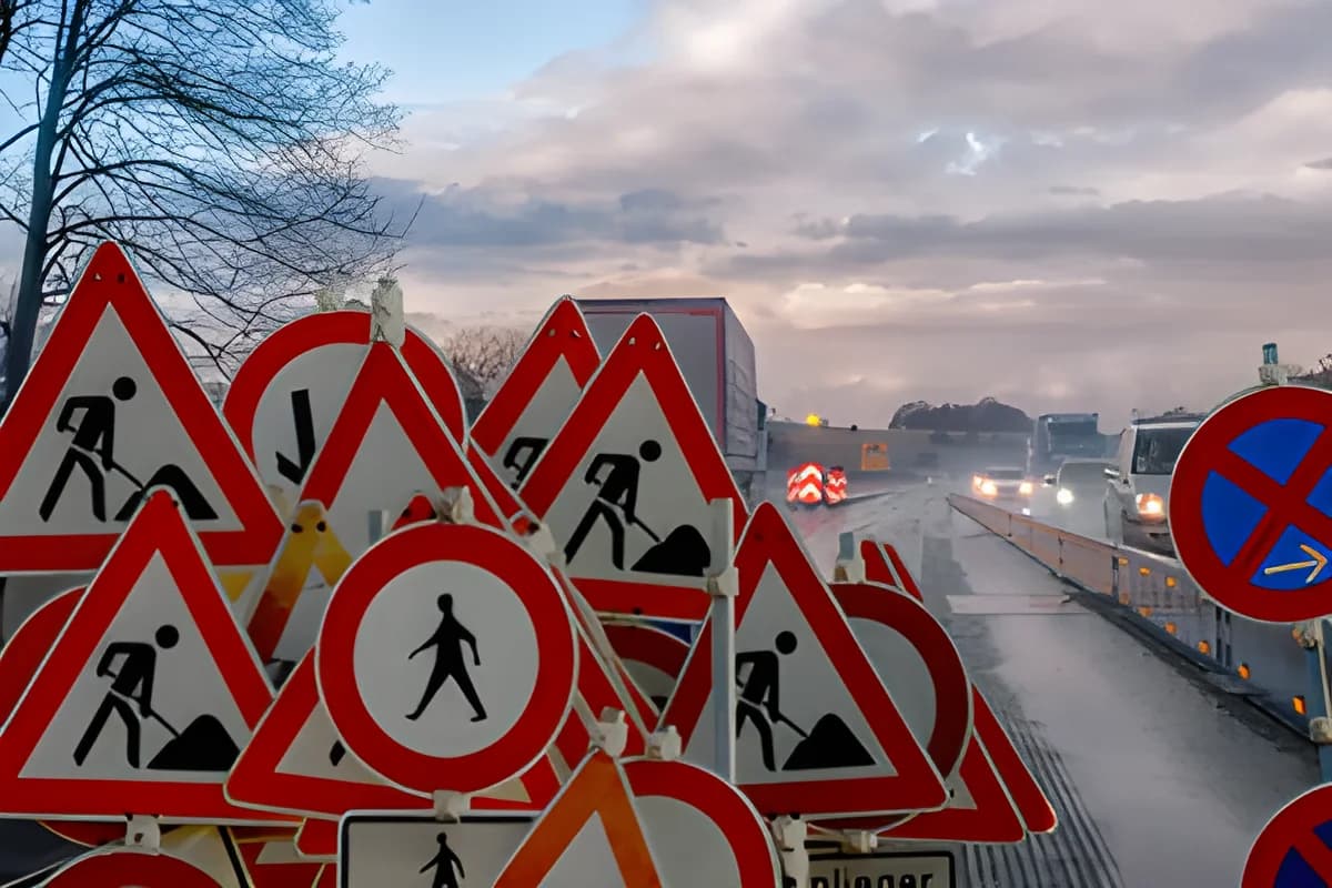Cluster of multiple traffic signs at roadside near highway