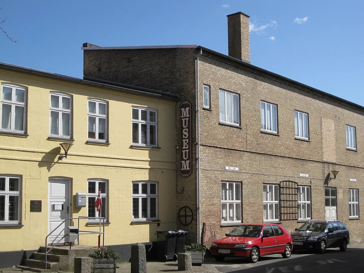 Street view of Slagelse Museum building with parked cars.