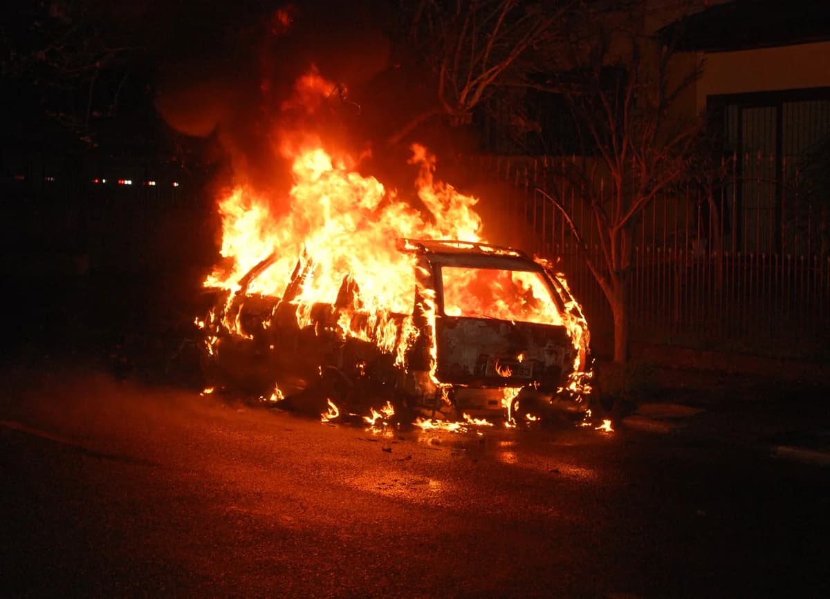 Car burning fiercely on a dark street