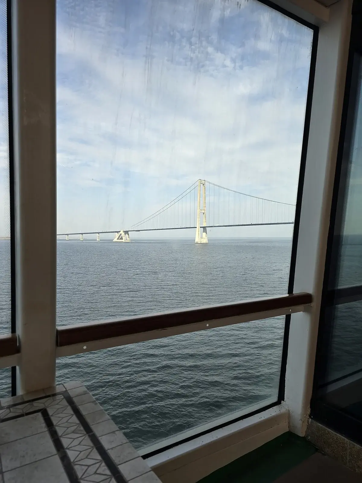 The Storebælt Bridge seen across the water through a ship window.