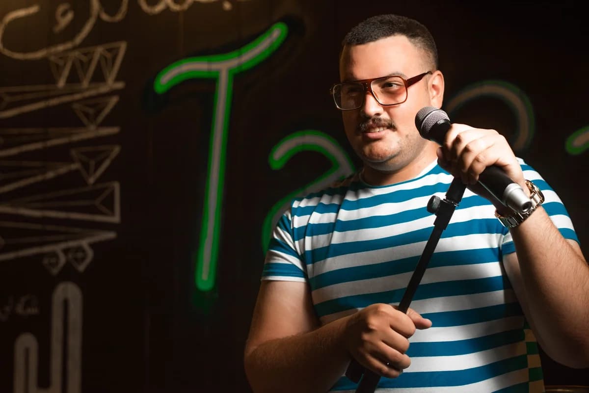 Male stand-up comedian holding microphone on stage