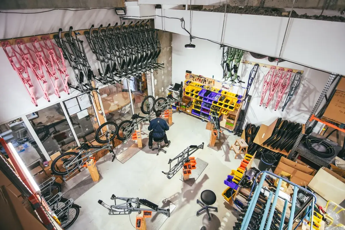 An organized bicycle workshop with bike frames and parts laid out for assembly.